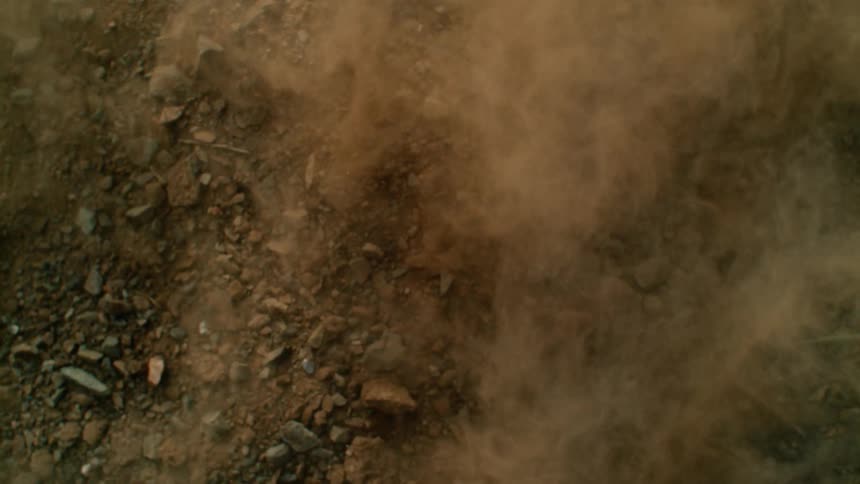 Rocks and dust fly into the air as the ground vibrates