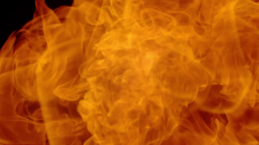 A fire bursts in a dark area