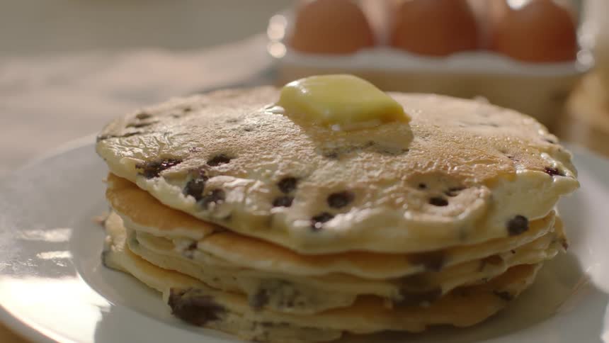 Butter melting on top of stack of blueberry pancakes