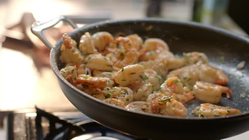 Shrimp is being cooked on a hot pan