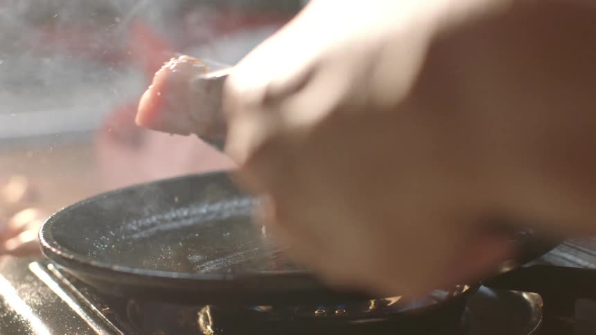 A steak is flipped on a pan