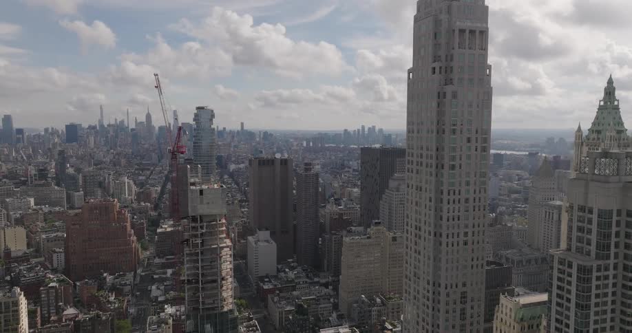 An aerial shot pushes in on the vast New York City skyline, then tilts down to a birds-eye view of the streets and rooftops below