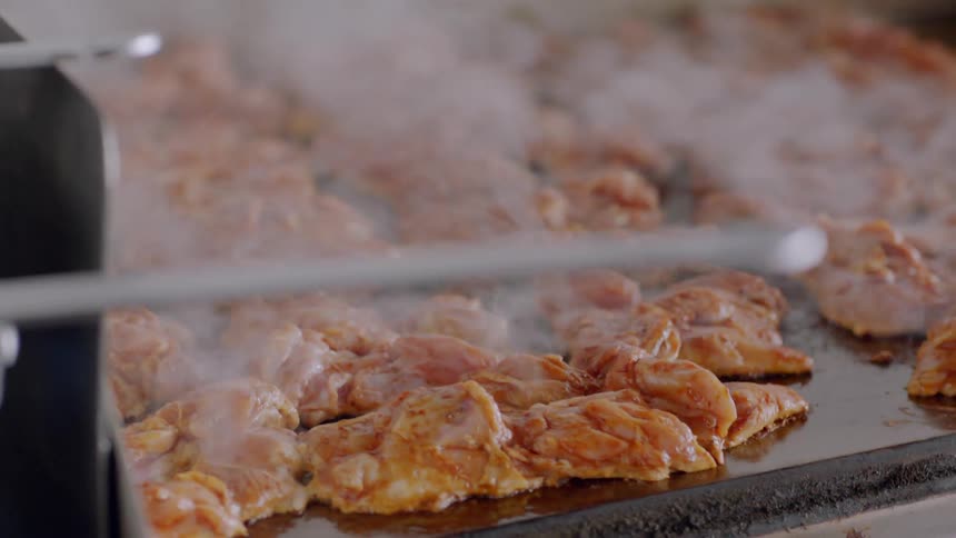 Meat sizzles on a cooking surface