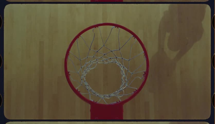 A top-down, vintage-style view shows a basketball player's shadow as they practice shooting and dunking on an indoor court