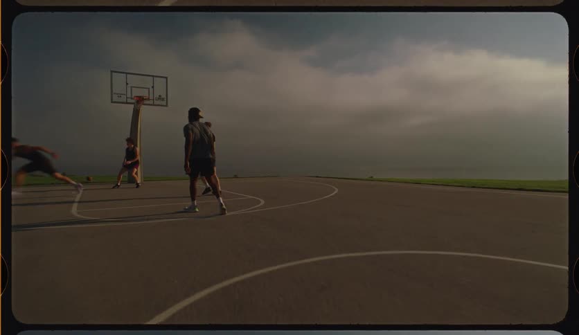 Cinematic slow motion shot of a group of friends playing a competitive game of basketball on an outdoor court