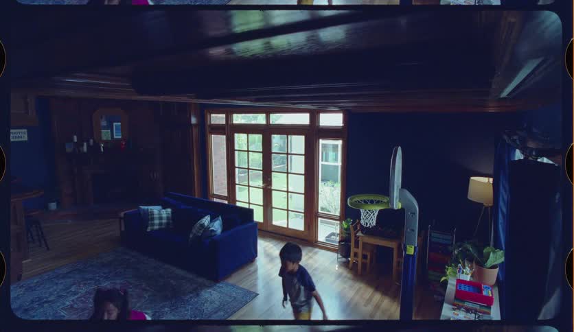 High angle shot of a young brother and sister playfully shooting hoops on a toy basketball goal in their living room
