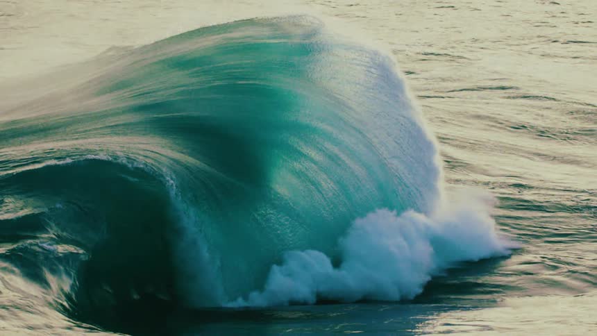 A powerful ocean wave forms and breaks in dramatic super slow motion with churning whitewater and spray