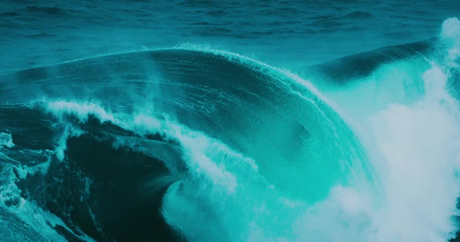 A majestic, color-graded turquoise ocean wave builds and breaks in dramatic super slow motion