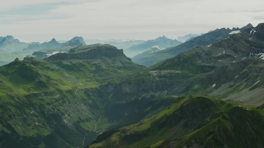 Mountain range covered in green grass on overcast day