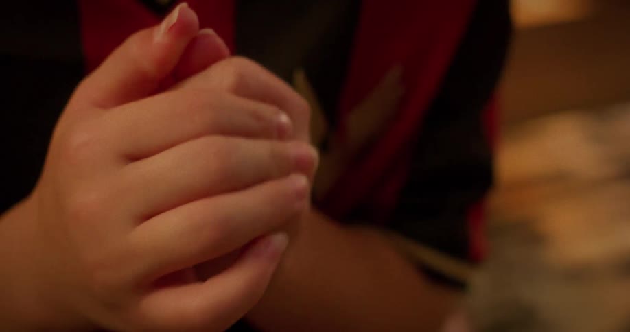 Close-up shot of a young child's hands fidgeting nervously