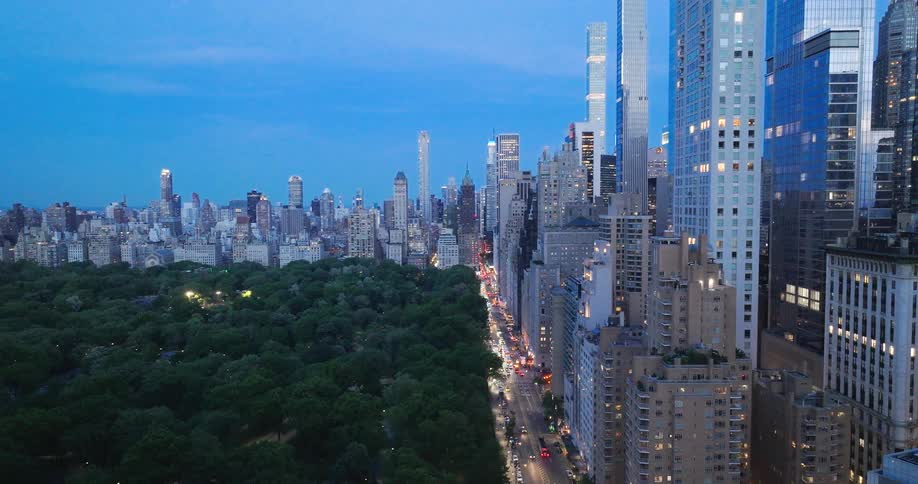 A slow upward aerial reveal of the magnificent Manhattan cityscape overlooking Central Park at dusk
