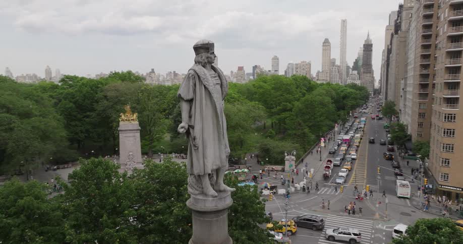 An aerial orbit of the Christopher Columbus monument at Columbus Circle reveals the bustling New York City streets and Central Park