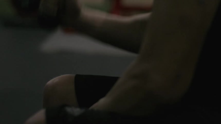 Man exercising while sitting down pulls down on a cord