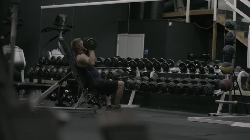 A man is lifting weights in a gym
