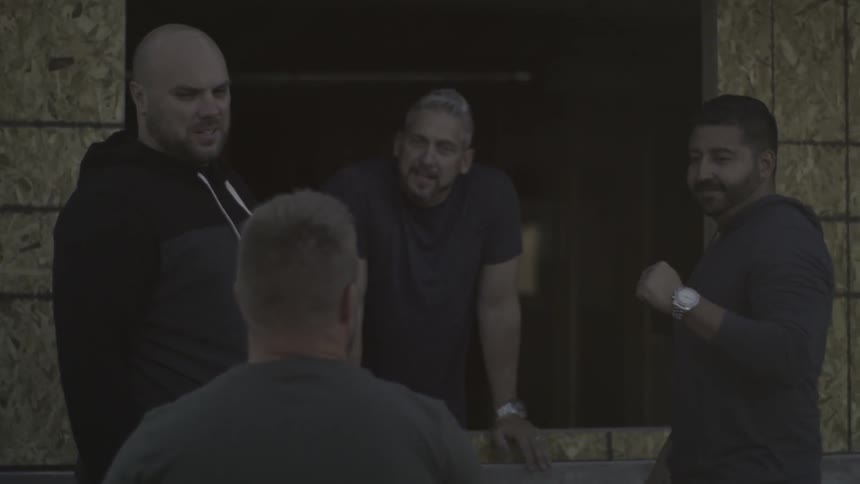 A man wheels in his chair over to some other men