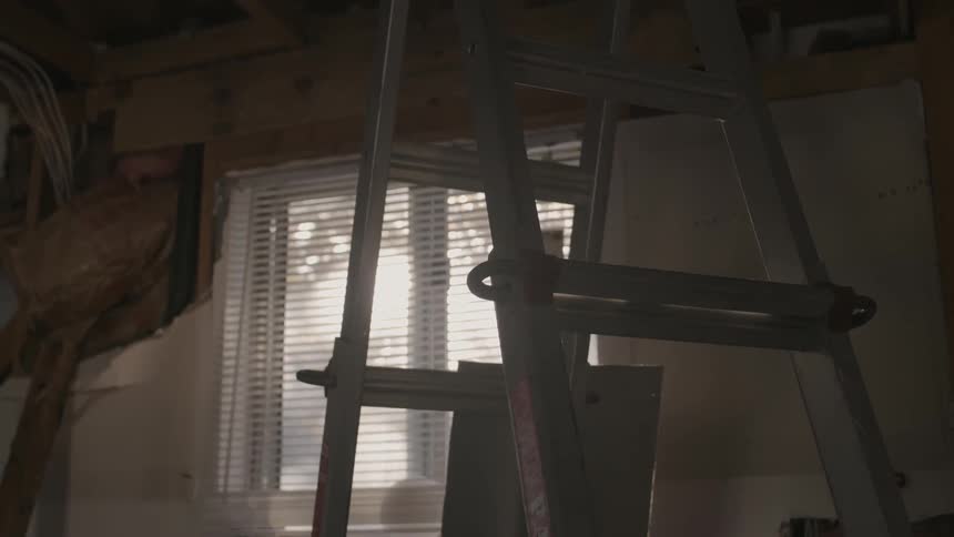Sunlight shines through a window and onto a ladder