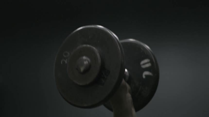 A man is lifting a weights above his head with one arm