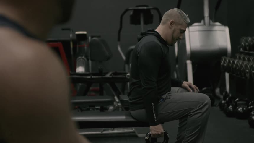 Two men are lifting weights in a gym