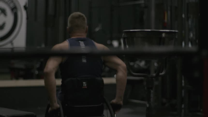 A man in a wheelchair navigates a gym