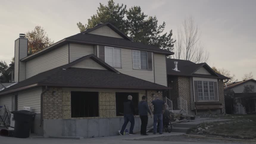 People walk over to the front of a house
