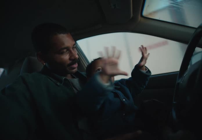 A loving father and his curious toddler share a special moment of wonder while going through an automatic car wash