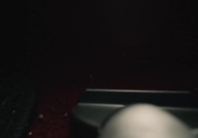 First-person perspective of vacuuming the dirty red carpet floor of a car interior