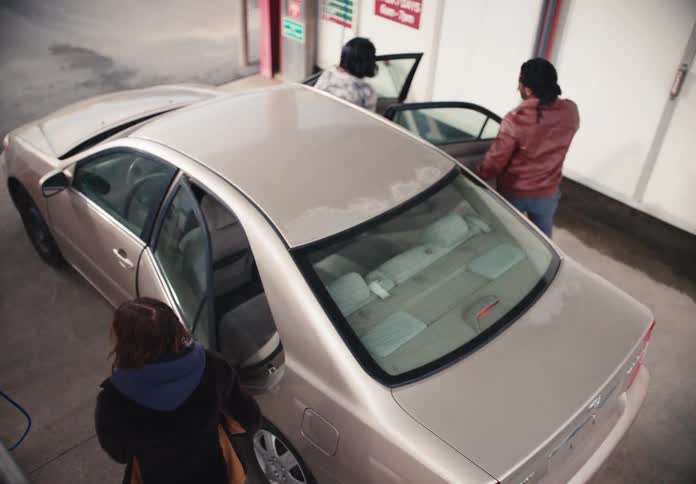 High angle shot of a group of friends arriving at a self-service car wash to clean their car together