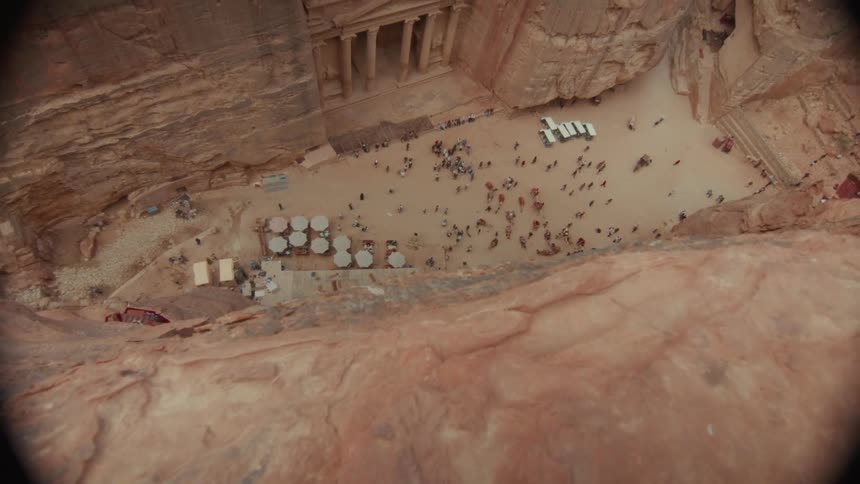A stunning high-angle shot reveals the bustling crowds of tourists in front of the ancient Treasury building in Petra, Jordan