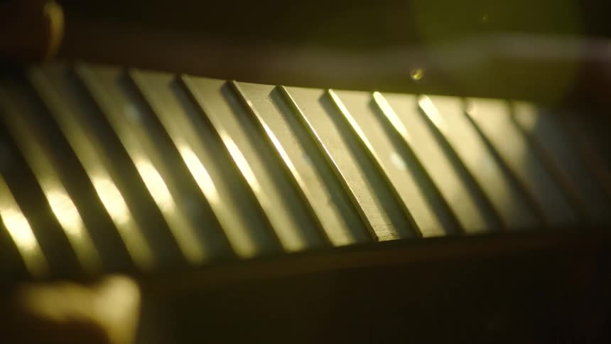 A moody, dramatic close-up of a guitar's fretboard, with golden light catching the frets