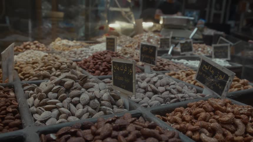 An assortment of fresh nuts, including almonds and cashews, are for sale at a local food market