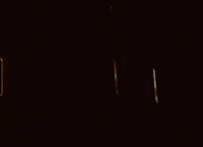 A vintage Super 8 film captures a brilliant fireworks display exploding in the dark night sky
