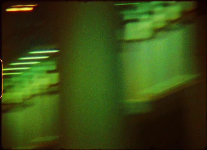 Vintage Super 8 film captures the chaotic and colorful flashing lights of an amusement park ride at night