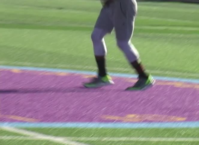 A close-up of a football player's feet doing fast footwork drills on a turf field