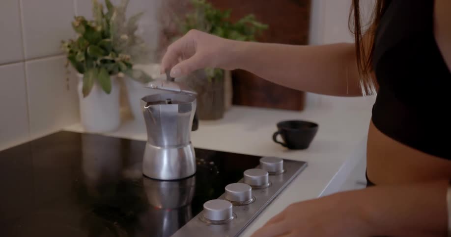 A woman is making coffee on the stove top