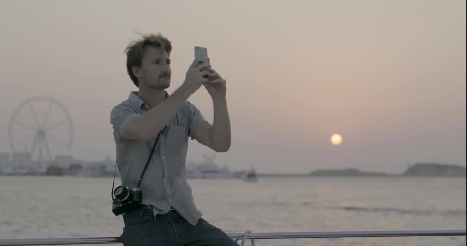 A man takes a photo from a boat