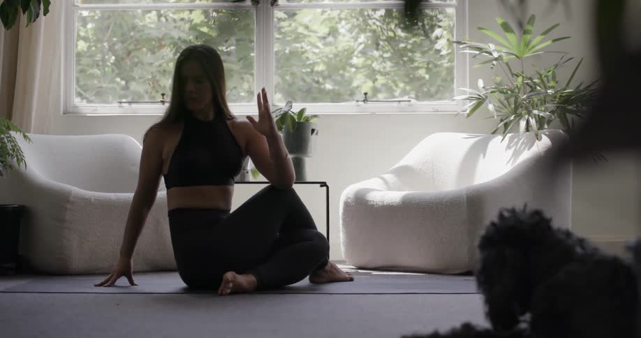 Woman stretches on an exercise mat in a living room