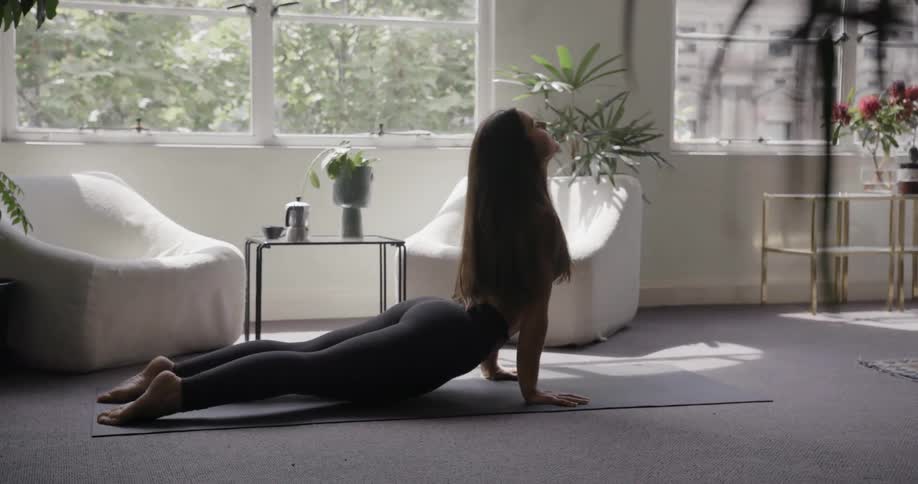A woman does a yoga pose on a yoga mat