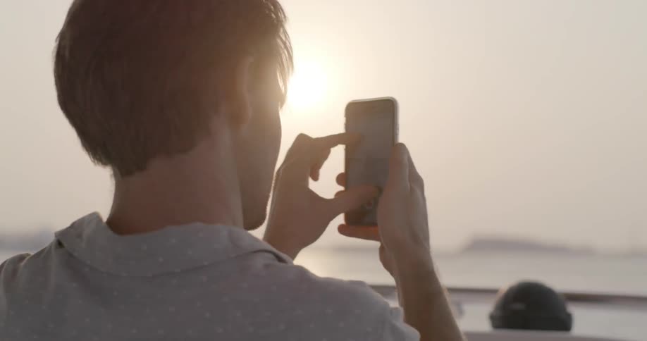 A man uses his phone on a boat