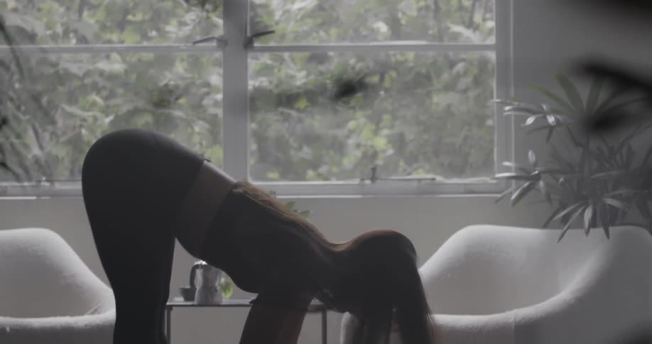 A woman leans forward performing yoga