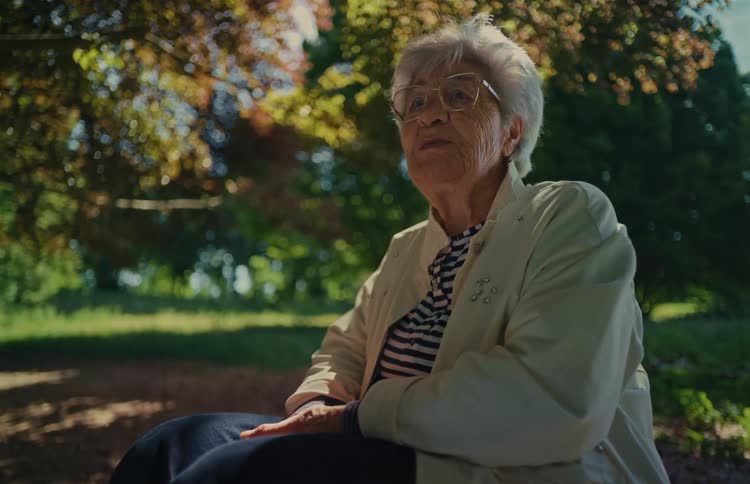 Low-angle shot of a grandmother telling a story while relaxing in a park on a beautiful day
