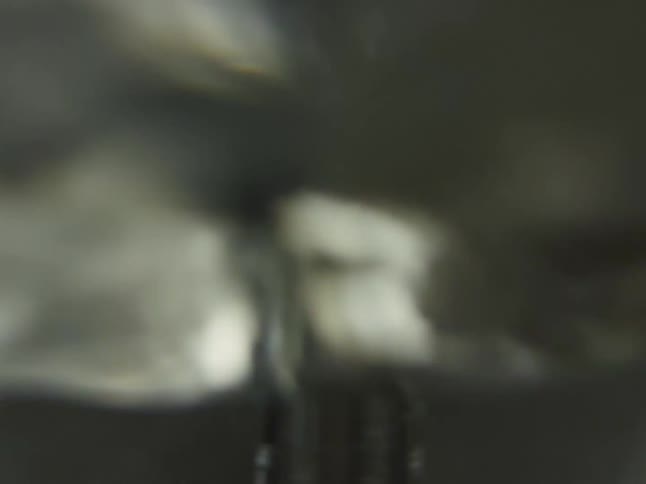 An abstract, out-of-focus close-up shows a mechanical mixer blade spinning rapidly in a seamless loop