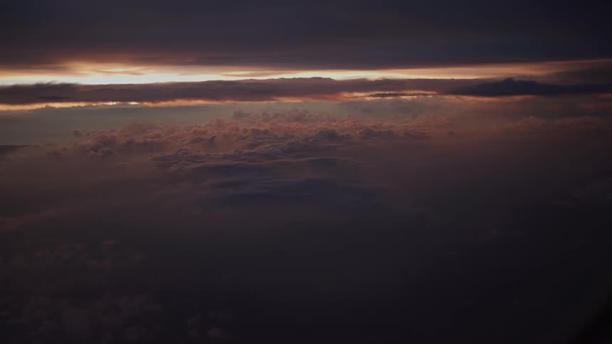 An awe-inspiring aerial view captures a moody and dramatic sunset over a vast sea of clouds