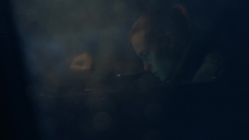 A man looking down in darkness
