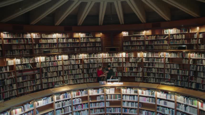 People stand on the round upper level of a library