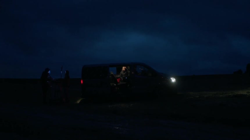 A van is parked in a rural area at night
