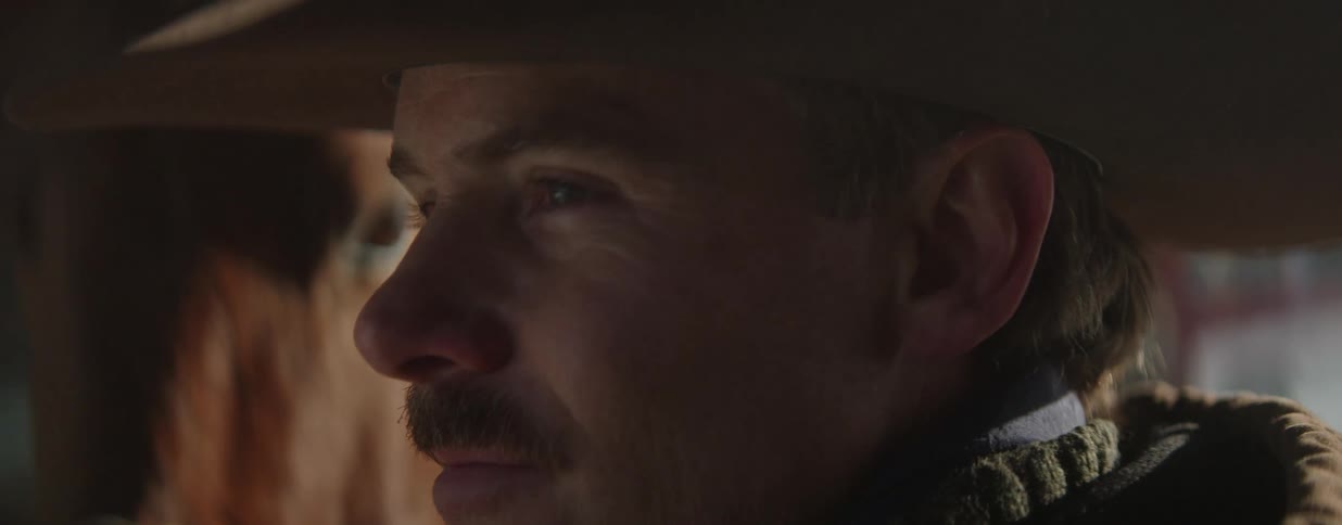 Cinematic close-up portrait of a pensive cowboy in a hat, with his horse in the background