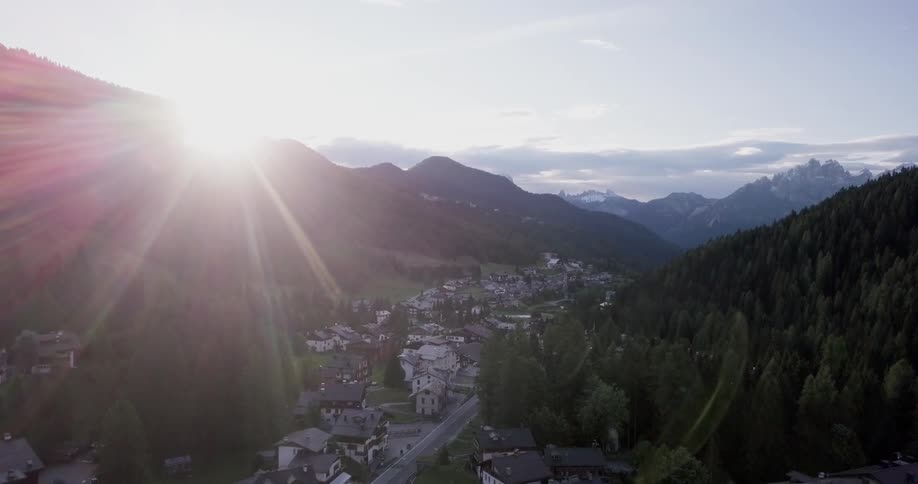 Sunlight shining over mountains above a small town