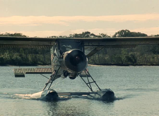 A classic seaplane taxis across the sparkling water of a river in this vintage 1980s archival footage
