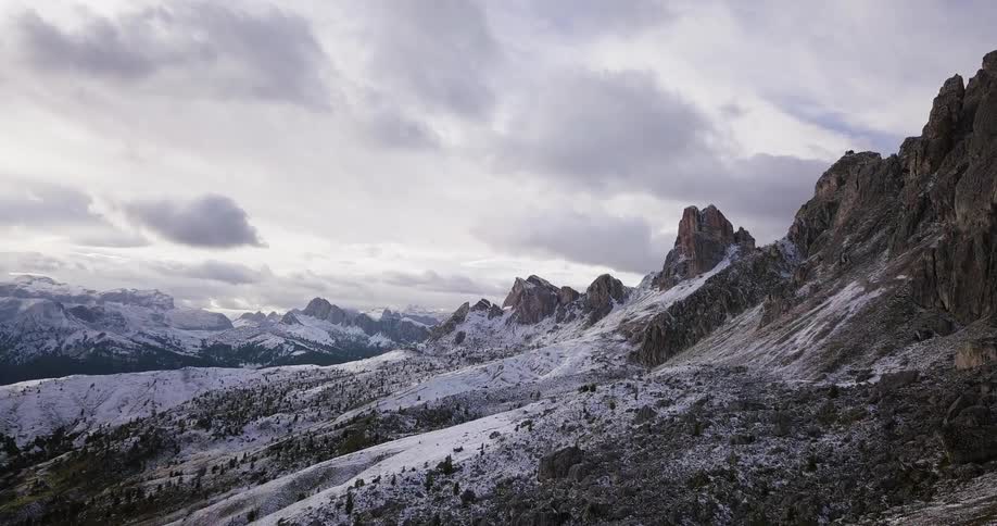 Clouds float over a snowy mountain range