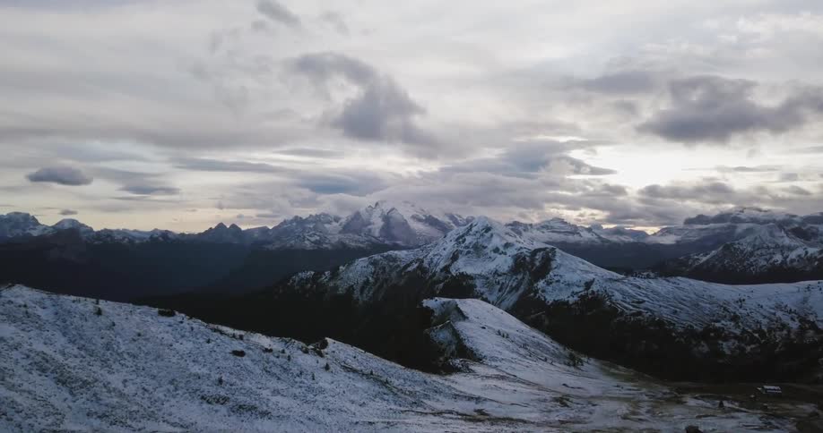 Clouds hover over a snow-covered mountain range